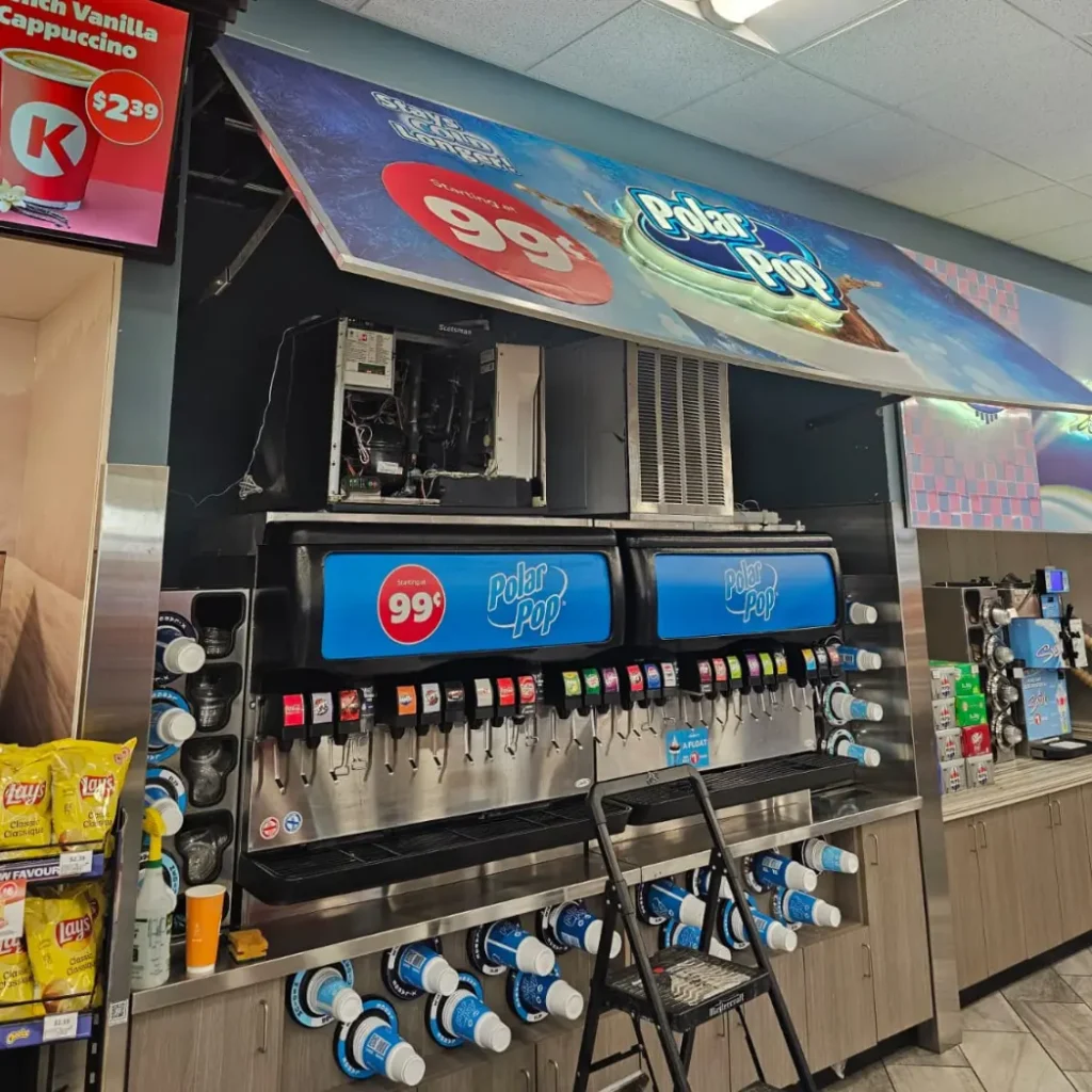 Technician servicing commercial Polar Pop beverage cooler and soda fountain equipment inside Calgary convenience store – Express Refrigeration Ltd commercial refrigeration experts