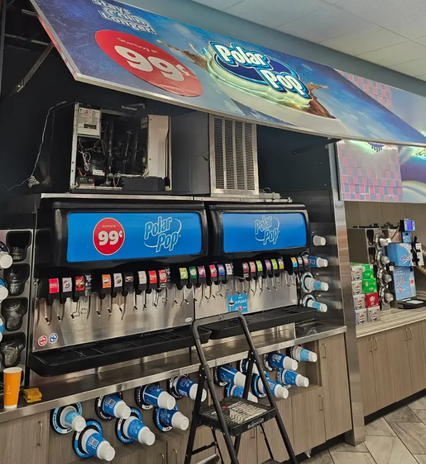 Technician servicing commercial Polar Pop beverage cooler and soda fountain equipment inside Calgary convenience store – Express Refrigeration Ltd commercial refrigeration experts
